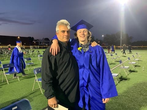 An embrace on the field at a graduation ceremony